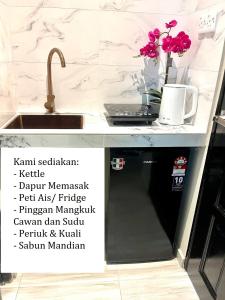 a kitchen counter with a sink and a dishwasher at CASA ADELIA STUDIO SUNGAI KARANG BALOK in Kampung Sungai Karang