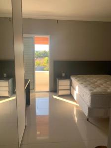 um quarto com uma cama e uma grande janela em Chacara La Bela em Indaiatuba