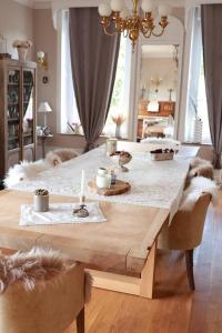 - une grande table en bois dans un salon avec des chiens se tenant autour dans l'établissement Au beau séjour, 