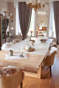 a large wooden table in a living room with dogs laying around it at Au beau séjour in Boulzicourt