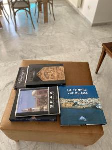three books sitting on a coffee table at Lac 2 apartement in Tunis