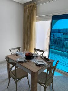 a wooden table with chairs and a bowl of fruit on it at Lac 2 apartement in Tunis