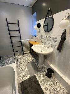 a bathroom with a sink and a mirror and a tub at Au beau séjour in Boulzicourt