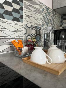 two white vases sitting on a counter in a kitchen at Уютная студия с видом на Ботанический парк in Astana