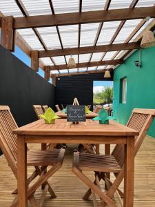 a dining room with a wooden table and chairs at La Maison Verte in Le Tampon