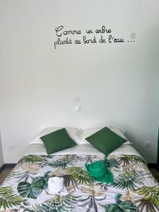a bedroom with a bed with a sign on the wall at La Maison Verte in Le Tampon