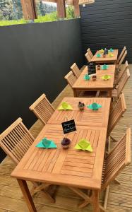 - une table en bois avec des chaises et des bols de nourriture dans l'établissement La Maison Verte, à Le Tampon