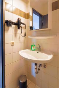 La salle de bains est pourvue d'un lavabo et d'un miroir. dans l'établissement K-UNITs: Lübeck Roter Löwe - City Nahes Appartement, à Lübeck