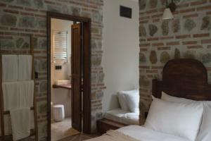 1 dormitorio con espejo, 1 cama y 1 silla en Elwood Hotel en Rize