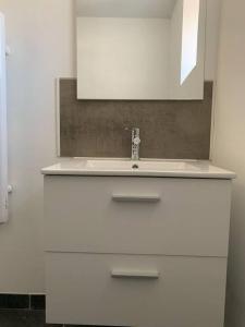 a bathroom with a white sink and a mirror at La chambre de Zé in Tournus