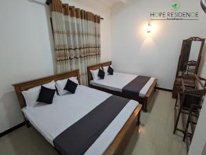 una camera con due letti e una sedia di Hope residence a Anuradhapura