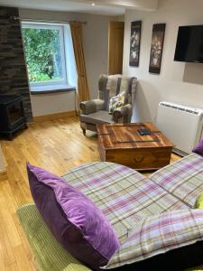 a living room with two beds and a coffee table at The Mews 2 bedroom with private parking in Oban