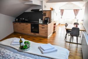 a room with a kitchen and a table with a bottle of wine at Studio apartment OAZA in Sisak