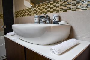 a bathroom sink with cups and towels on a counter at Studio apartment OAZA in Sisak +9 photos