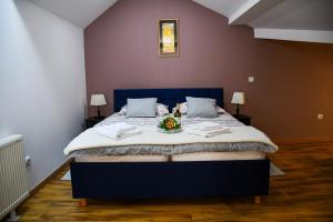 a bedroom with a bed with a bowl of flowers on it at Studio apartment OAZA in Sisak
