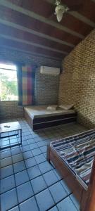 um quarto com uma cama e uma mesa em Casa Vitral - Em condomínio fechado - Aldeia/PE em Pau dʼAlho