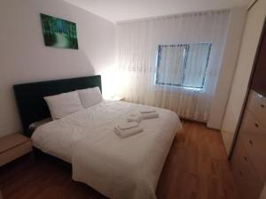 een slaapkamer met een bed met twee handdoeken erop bij Home Residence in Piatra Neamţ
