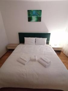een bed met twee witte handdoeken erop bij Home Residence in Piatra Neamţ