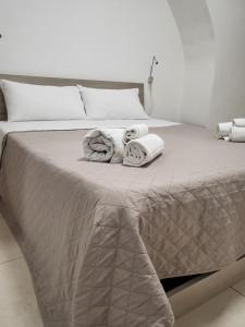 Una cama con toallas y almohadas. en Casa Giulia & AL Duomo en Siracusa
