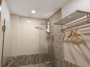 a shower with a glass door in a bathroom at Dy Heritage Suites in Vigan