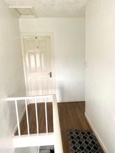 an empty room with a white door and a staircase at Single bed in a peaceful house in Morriston in Morriston