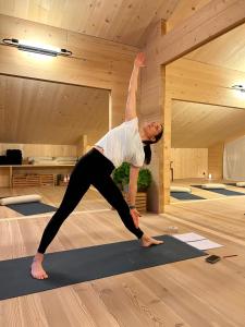 a man doing a yoga pose on a yoga mat at Berglodge Goms (Hotel) in Münster