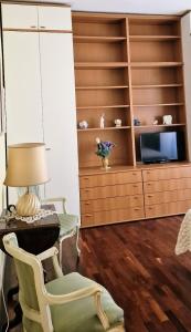 - un salon avec une télévision, une chaise et une armoire dans l'établissement Casa Rosi, à Rome