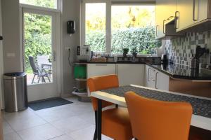 a kitchen with orange chairs and a table in it at tisOKE in Vught