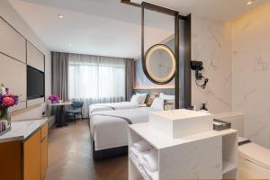 a hotel room with a bed and a sink at Imperial Traders Elong Hotel in Guangzhou