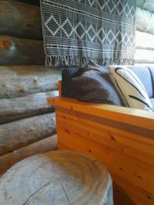 Schlafzimmer mit einem Holzbett und einem Holztisch in der Unterkunft Lumi - kelohirsimökki Rukalla, log cabin at Ruka in Kuusamo