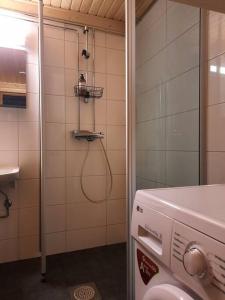 ein Bad mit einer Dusche, einem WC und einem Waschbecken in der Unterkunft Lumi - kelohirsimökki Rukalla, log cabin at Ruka in Kuusamo
