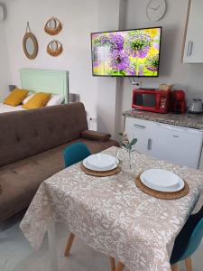 uma sala de estar com uma mesa e um sofá em Casa del Arco em Olvera