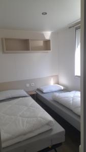 a bedroom with two beds and a window at Le Bois Dormant in Saint-Jean-de-Monts