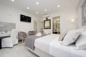 a white bedroom with a bed and a table and chairs at Roman Holiday Suites in Rome