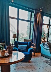 Edsbyns Hotell في Edsbyn: غرفة معيشة مع أريكة زرقاء وطاولة