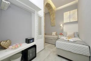 a small bedroom with a bed and a tv at Roman Holiday Suites in Rome