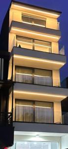 een hoog gebouw met veel ramen 's nachts bij P J Luxury Suites in Serres
