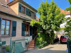 dom z niebieskimi okiennicami i drzewem przed nim w obiekcie Chez Rosa w mieście Haguenau