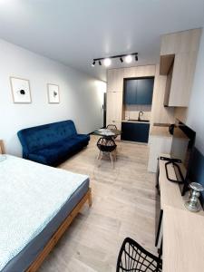 um quarto com uma cama e um sofá azul em AlfaHome Lodz em Lódź