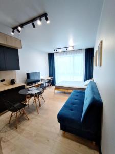 uma sala de estar com um sofá azul e uma cama em AlfaHome Lodz em Lódź
