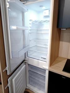 an empty refrigerator with its door open in a kitchen at AlfaHome Lodz in Łódź