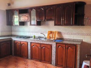 a kitchen with wooden cabinets and a sink at Villa La Palma 2, Imi ouaddar in Agadir nʼ Aït Sa