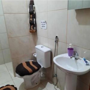 uma casa de banho com um WC e um lavatório em ITAÚNAS Pousada Nossa Palhoça em Itaúnas