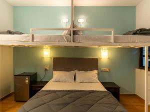 2 łóżka piętrowe w pokoju z łóżkiem w obiekcie Madpackers Goa w mieście Anjuna