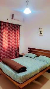 1 dormitorio con 1 cama con cabecero rojo en Appartement Beau Séjour 1, en Dakar