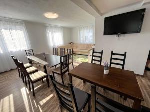 a dining room with tables and chairs and a flat screen tv at Green Hills Sibiu in Sibiu