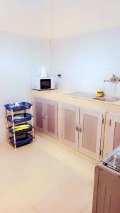 a kitchen with pink cabinets and a microwave at Appartement Beau Séjour 1 in Dakar