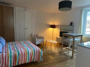a bedroom with a bed and a desk and a table at Studio à Noyarey avec wifi in Noyarey +3 photos