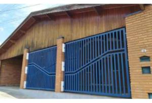 a building with a blue gate on the side of it at Albuquerque nro36 casa 3 in Campinas
