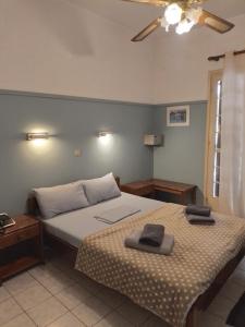 1 dormitorio con 2 camas y ventilador de techo en Miranta Hotel - Apartments & Studios, en Aegina Town